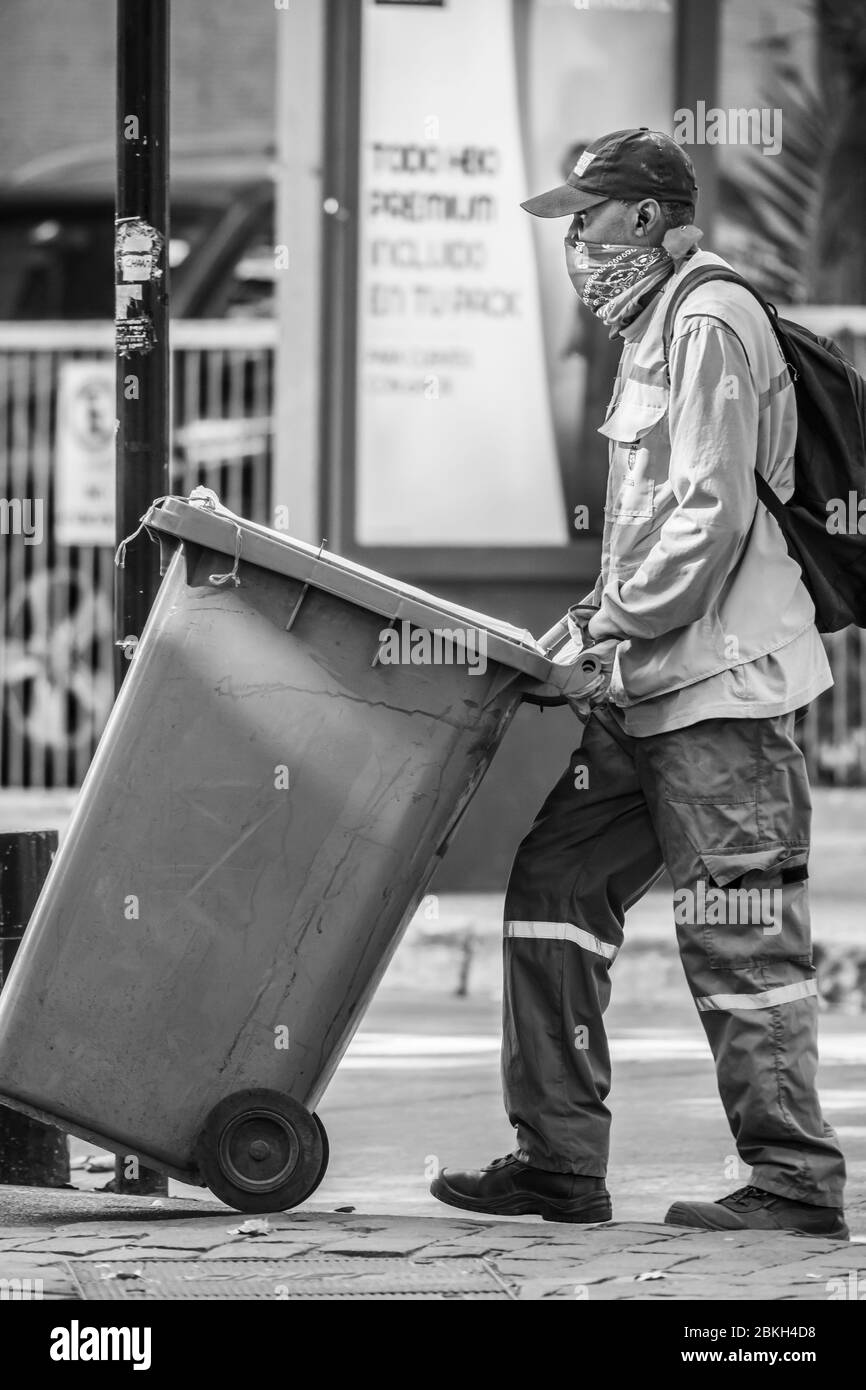 Travailleur de nettoyage immigrant inquiet en travaillant sur les rues de Santiago nettoyage pendant l'infection à coronavirus COVID-19 avec protection précaire Banque D'Images