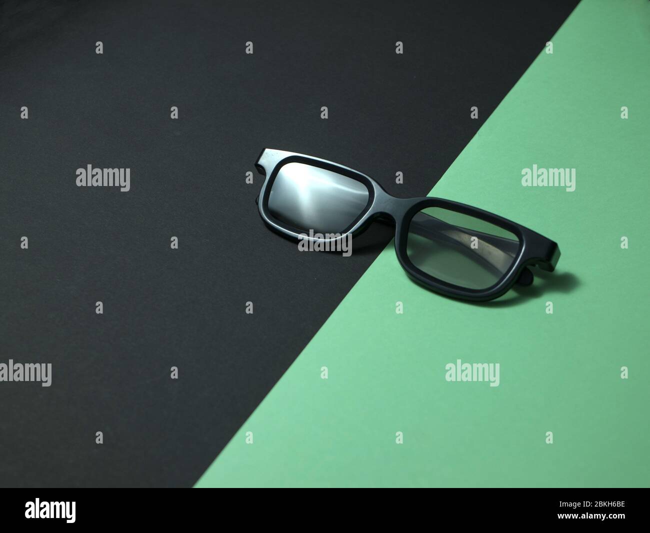 Lunettes 3D en plastique noires sur fond coloré. Banque D'Images