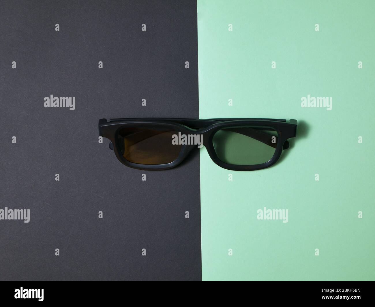 Lunettes 3D en plastique noires sur fond coloré. Banque D'Images