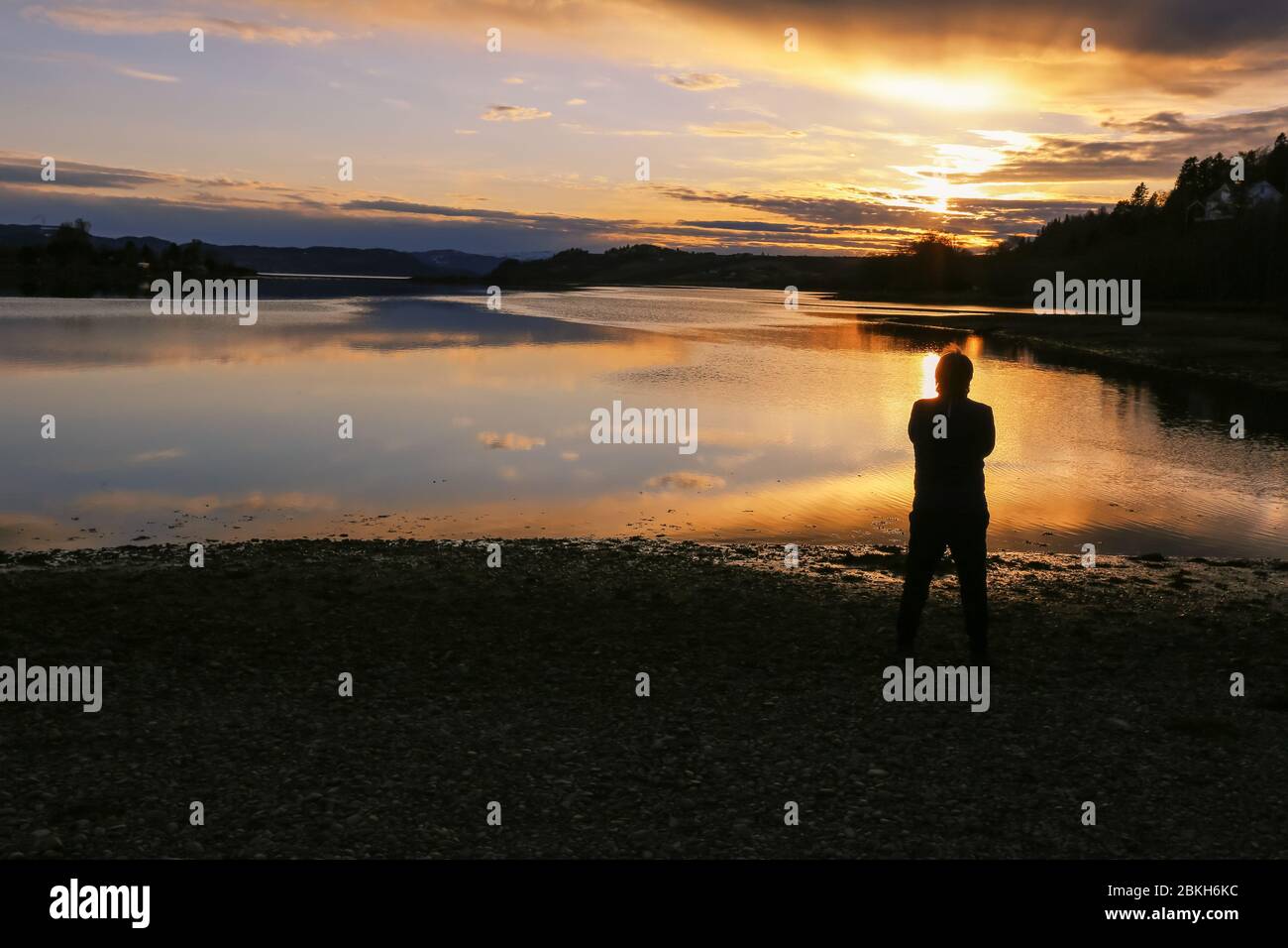 L'homme regardant le coucher du soleil sur la rivière Gaula, Trondheim Banque D'Images