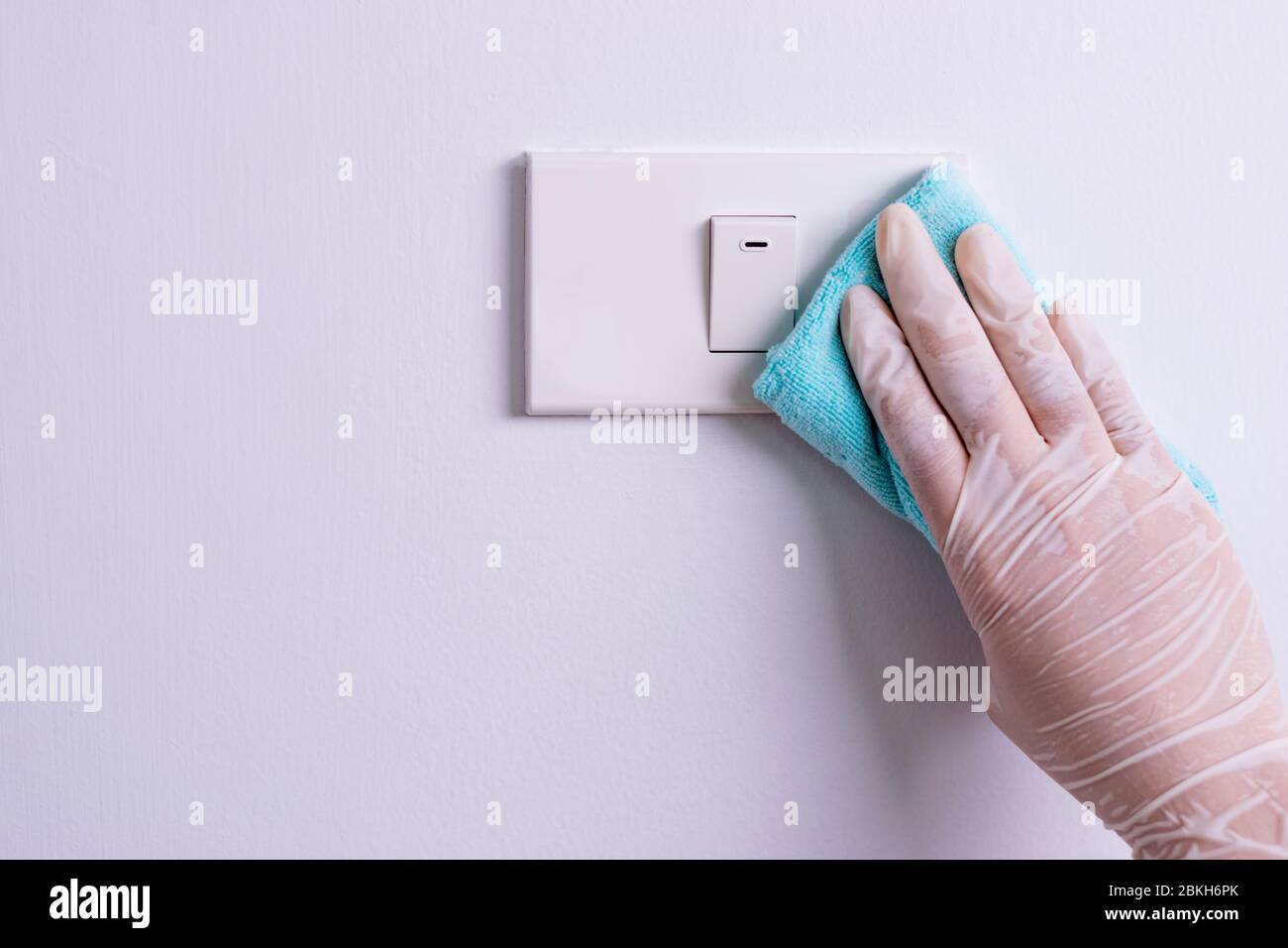 Femme mains pour nettoyer les interrupteurs lumineux protègent le coronavirus ou Covid-19. Copier l'espace. Banque D'Images