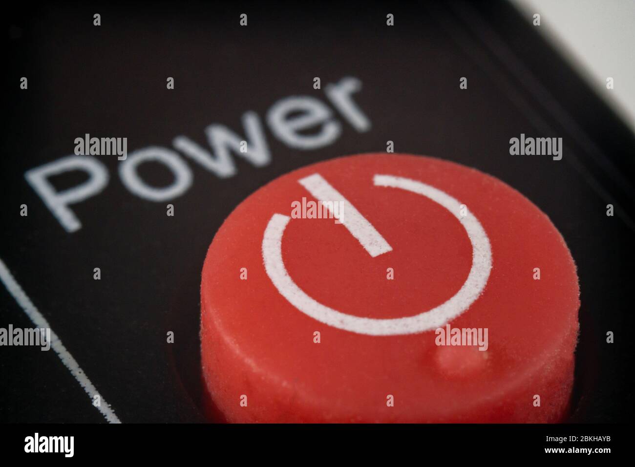 Macro extrême d'un bouton d'alimentation rouge sur une télécommande pour un téléviseur Banque D'Images