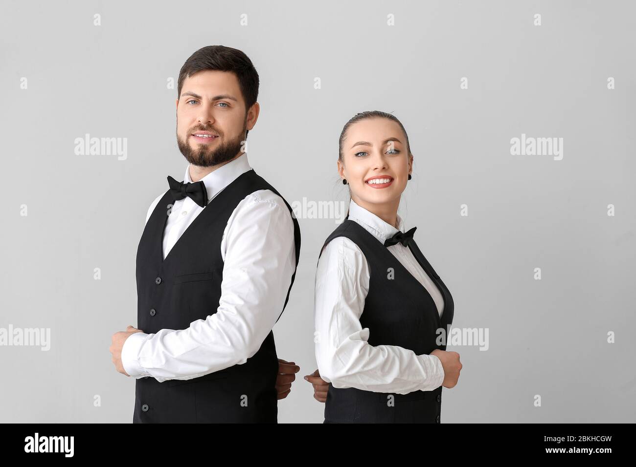 Serveurs mâles et femelles sur fond gris Banque D'Images