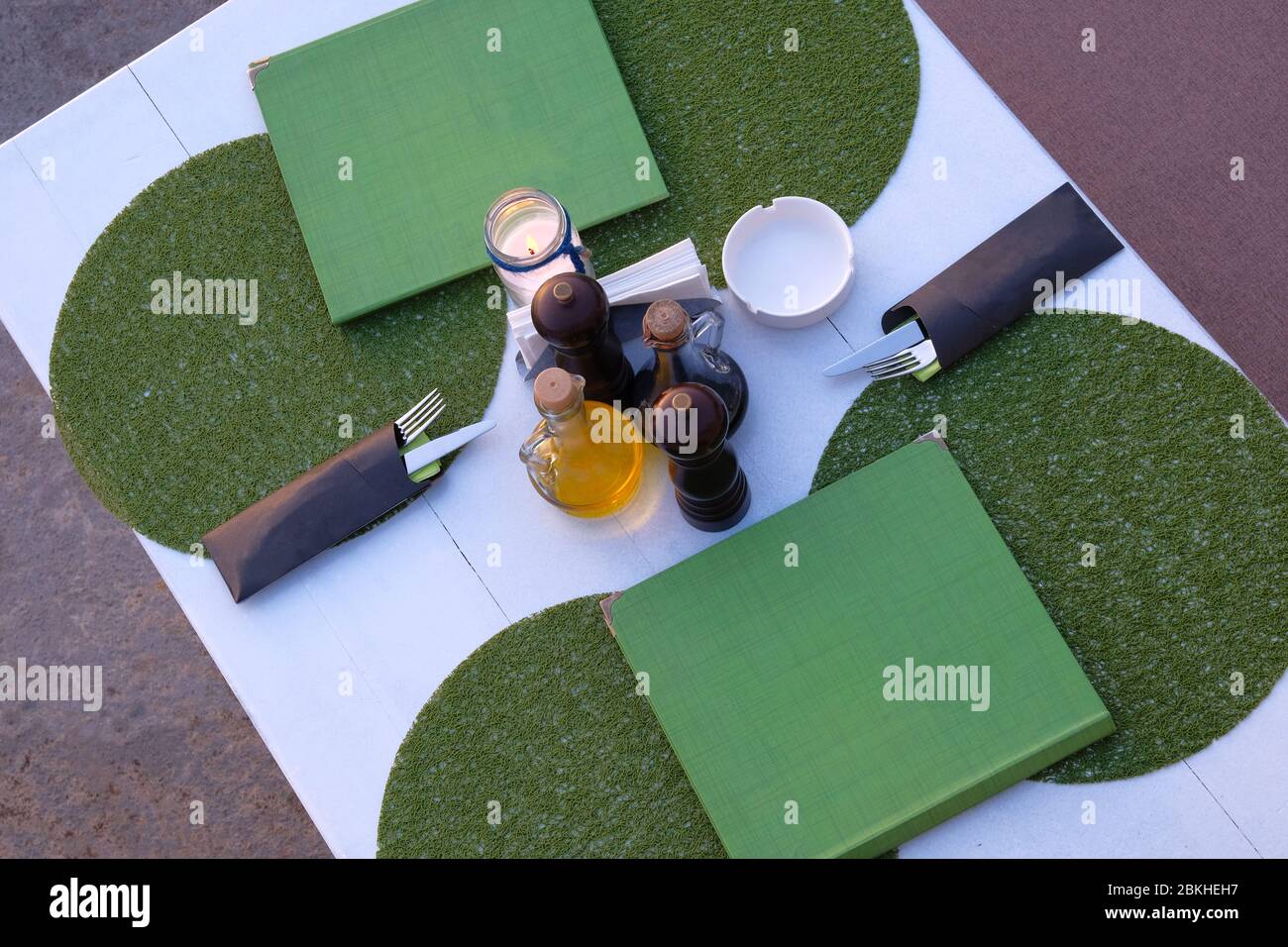 Table et service dans un café extérieur en soirée d'été. Terrasse d'été du restaurant en soirée. Vue de dessus. Banque D'Images Table et service dans un café extérieur en soirée d'été. Terrasse d'été du restaurant en soirée. Vue de dessus. Banque D'Images