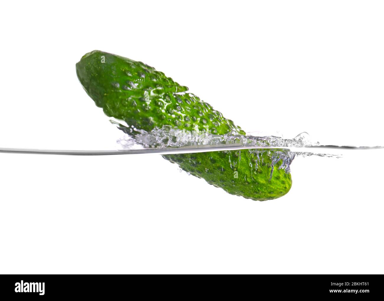Chute de concombre frais dans l'eau sur fond blanc Banque D'Images