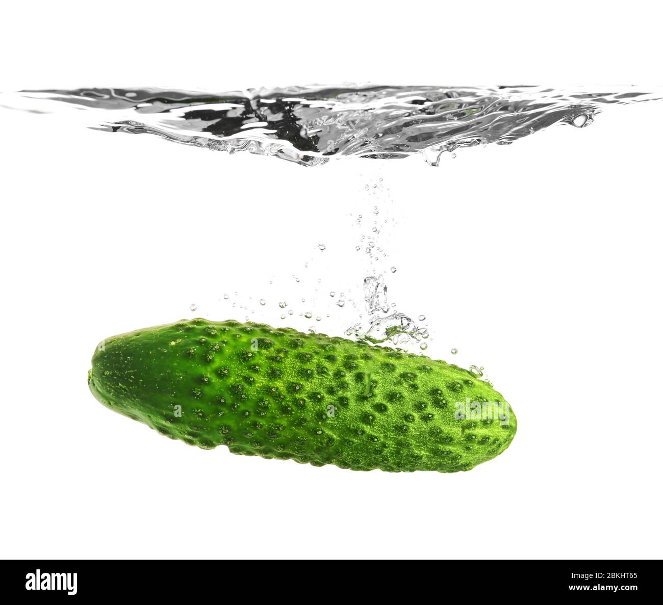 Chute de concombre frais dans l'eau sur fond blanc Banque D'Images