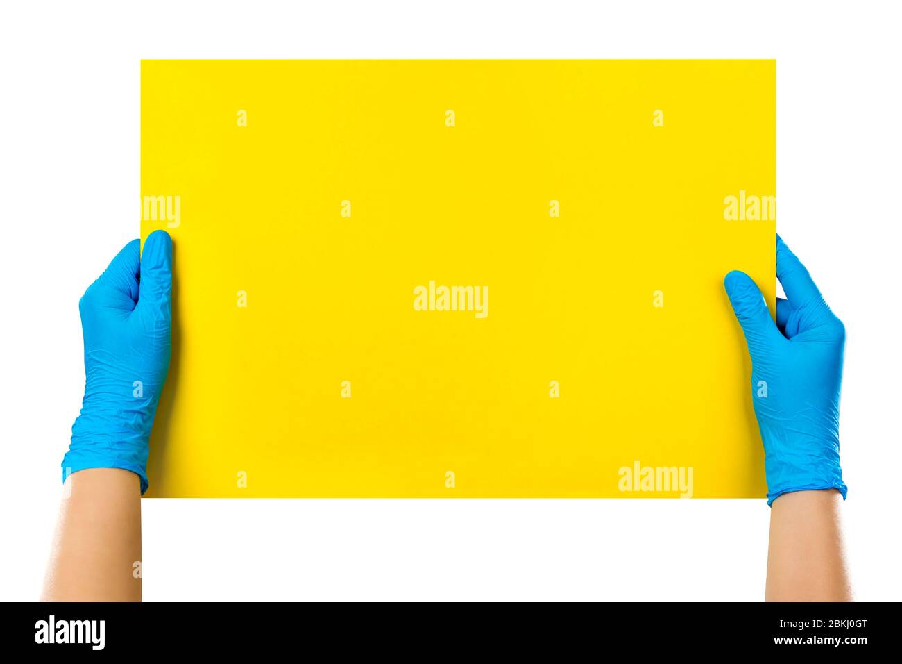 Carte jaune vide dans les mains du médecin, gants bleus avec espace de copie, isolée sur fond blanc. Masque inclus. Banque D'Images