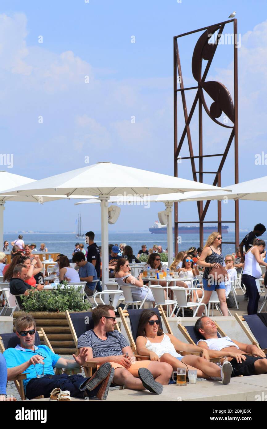 Portugal, Lisbonne, Ribeira das Naus, terrasse du café Quiosque Ribeira das Naus avec la sculpture sur les rives du Tage dédiée à l'artiste José Sobral de Almada Negreiros Banque D'Images