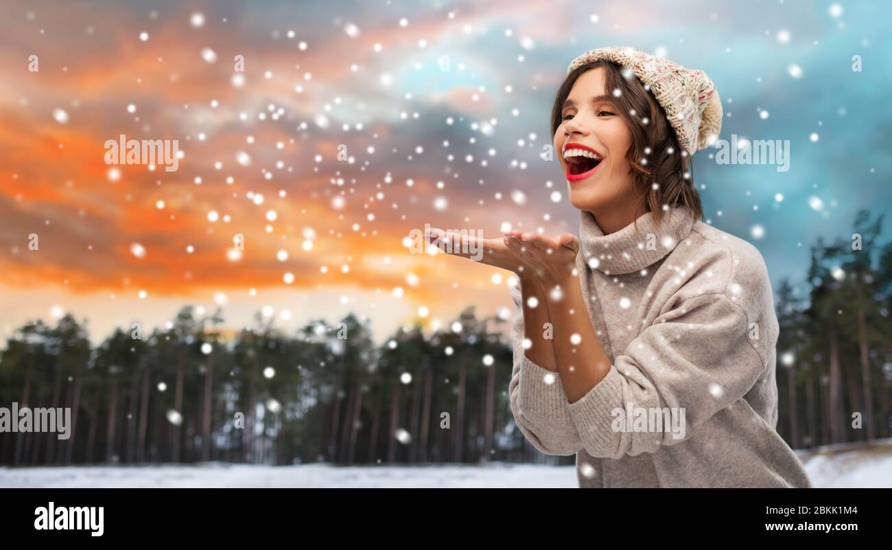 femme en chapeau envoyant un baiser d'air au-dessus de la forêt d'hiver Banque D'Images