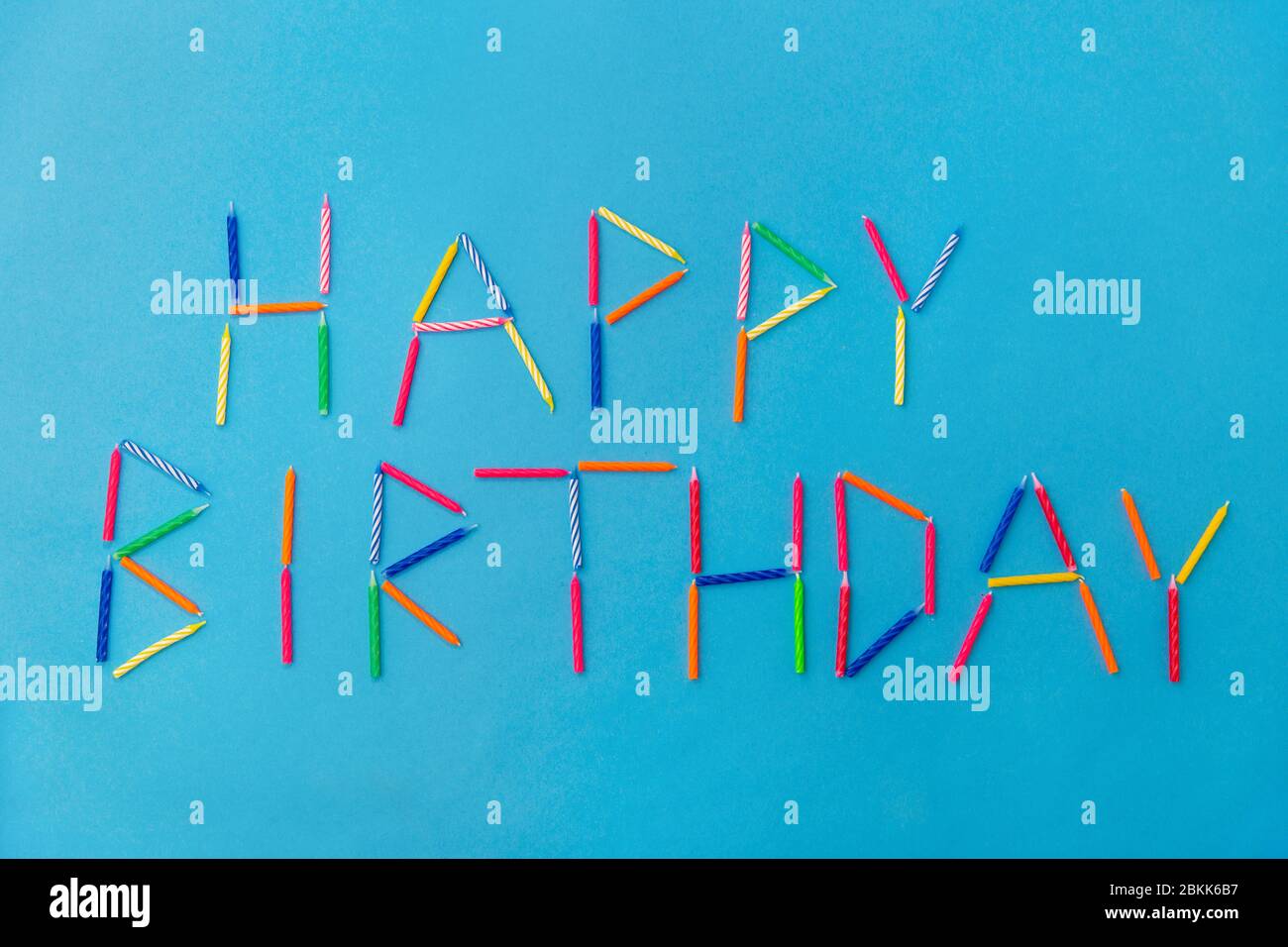 mots joyeux anniversaire fait de bougies sur bleu Banque D'Images