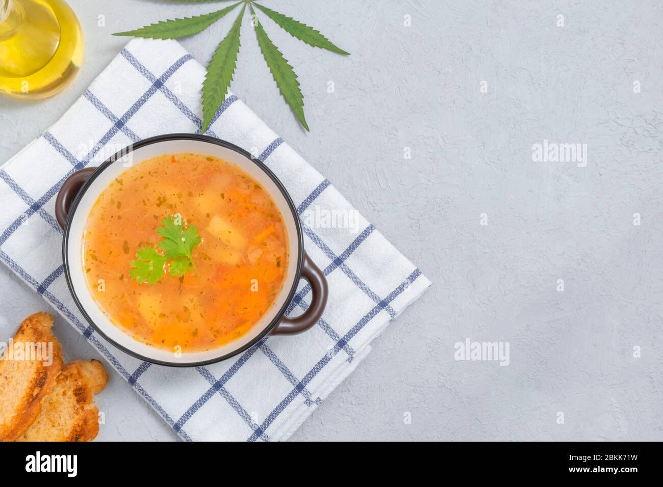 Soupe infusée de cannabis dans un bol sur fond neutre clair avec espace pour les copies Banque D'Images