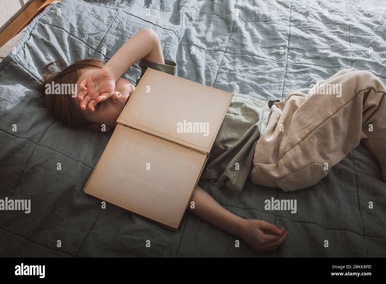 Un petit garçon se réveille après un livre ennuyeux. Page de livre de maquette. Banque D'Images