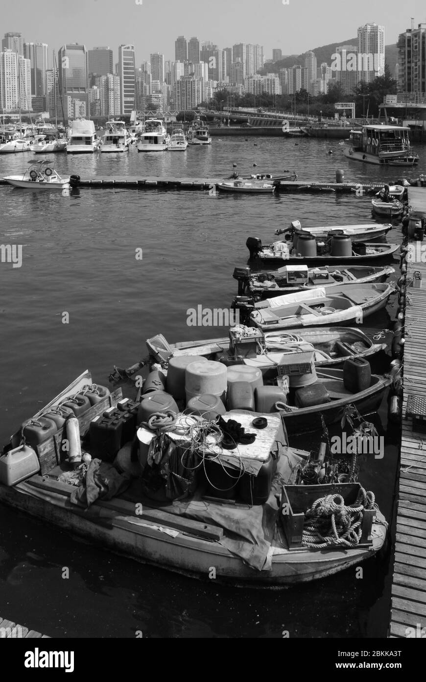 Bateaux de pêche dans le port Victoria de Hong Kong Skyline B&W. Banque D'Images