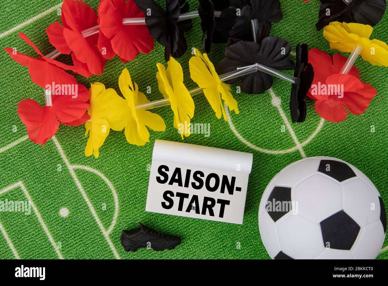 Saison Start en allemand signifie début de saison. Ballon de football avec  collier de fleurs dans les couleurs du drapeau allemand et calendrier Photo  Stock - Alamy