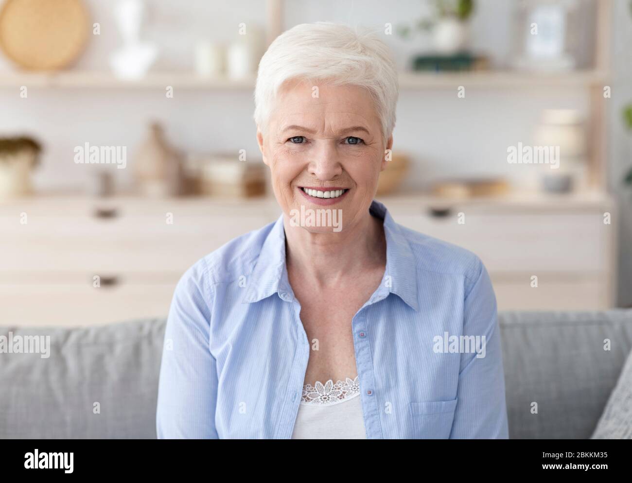 Portrait d'une belle femme âgée souriante posant à l'intérieur de la maison Banque D'Images