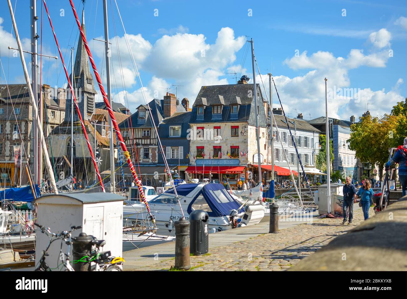 La pittoresque vieille pier et port de Honfleur, France, sur la côte normande de la Manche sur un après-midi ensoleillé comme un couple se promener par Banque D'Images