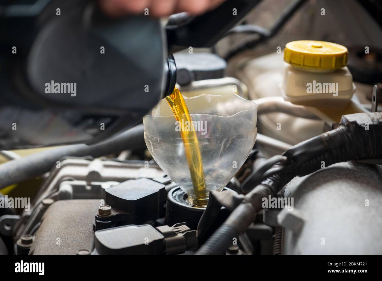 Faire l'appoint ou le remplacement avec de l'huile moteur neuve pour une  voiture lors d'une vidange d'huile et d'un entretien de voiture à l'aide d'un  entonnoir en plastique fait maison Photo Stock -