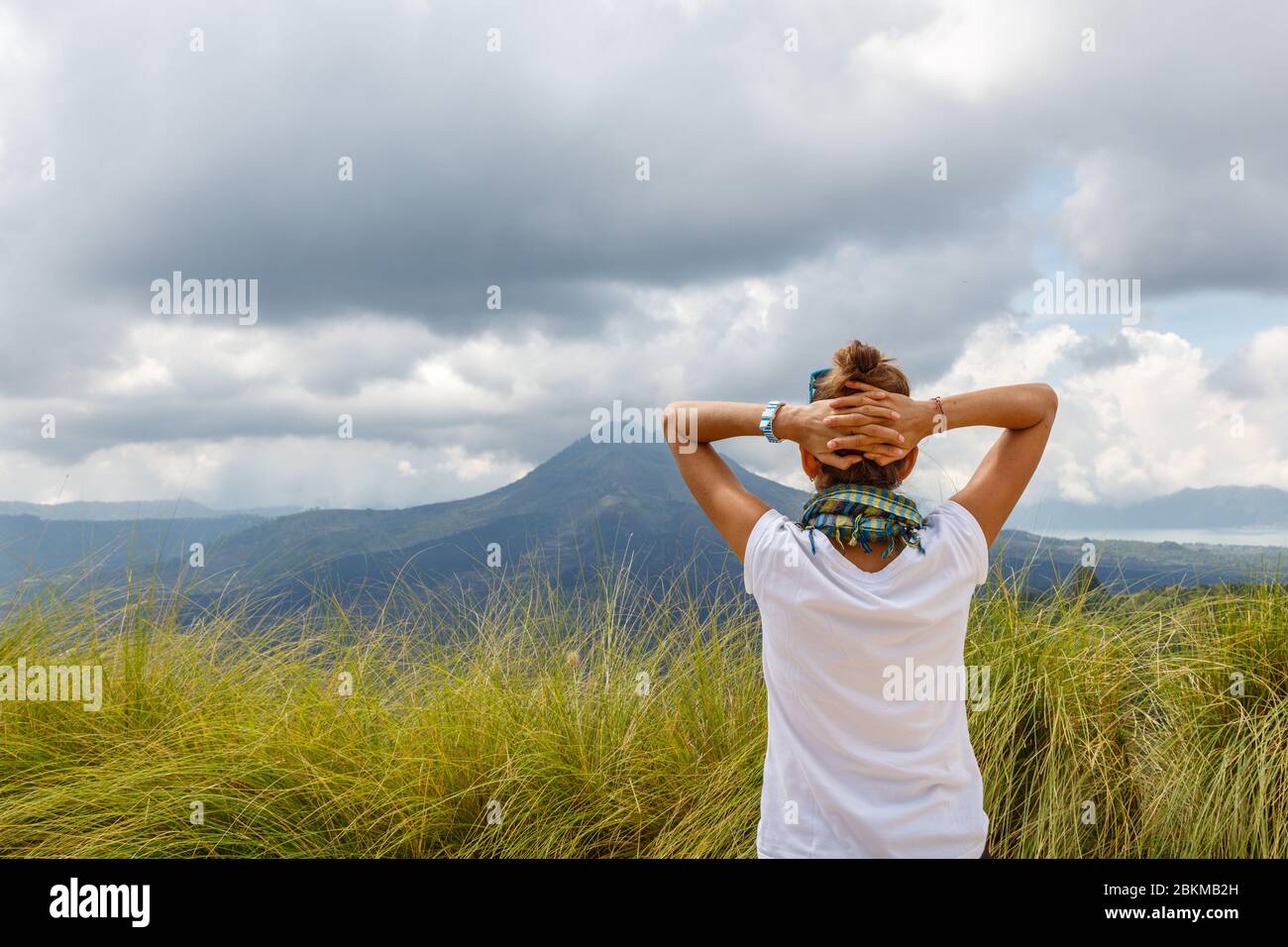 Une femme regardant la vue sur le volcan Batur (Gunung Batur) et le lac Batur (Danau Batur). Kintamani, Bangli, Bali, Indonésie. Banque D'Images