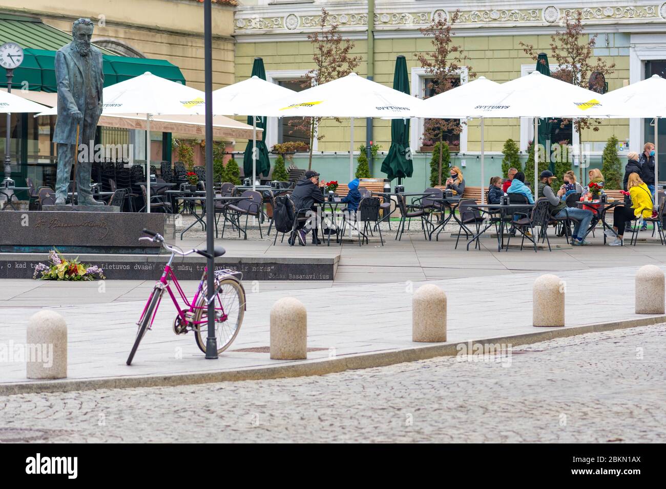 Bar et restaurant en plein air avec clients et serveuse avec masque et gant à Vilnius, capitale lituanienne rouvrant dans la vaste ville de café en plein air Banque D'Images