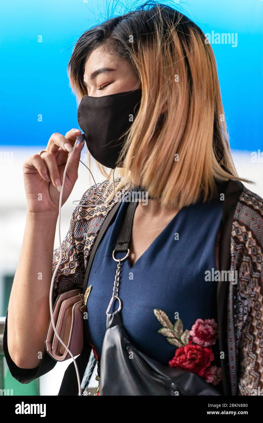 Travailleur de bureau asiatique avec masque et téléphone mobile pendant la pandémie Covid 19, Bangkok, Thaïlande Banque D'Images