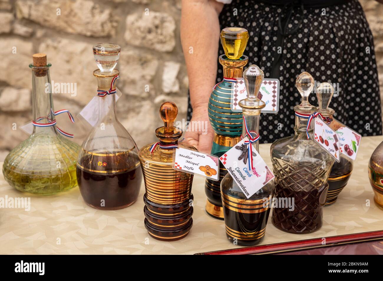 Collection de catafes traditionnelles peintes en or de verre remplies de fortes liqueurs croates typiques, telles que le mispel, le caroub, la cerise, le myrte et la rose à b. Banque D'Images