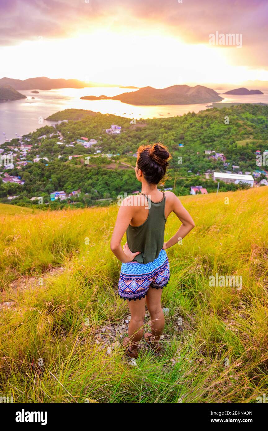 Fille regardant la ville et la baie de Coron depuis le Mont Tapyas sur l'île Busuanga au coucher du soleil - destination tropicale avec paysage paradisiaque, Palawan, P Banque D'Images