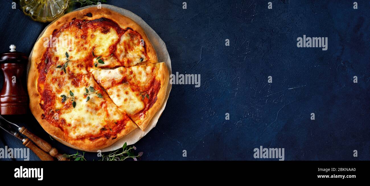 Vue de dessus de la délicieuse pizza végétarienne croustillante Margherita sur fond bleu foncé Banque D'Images