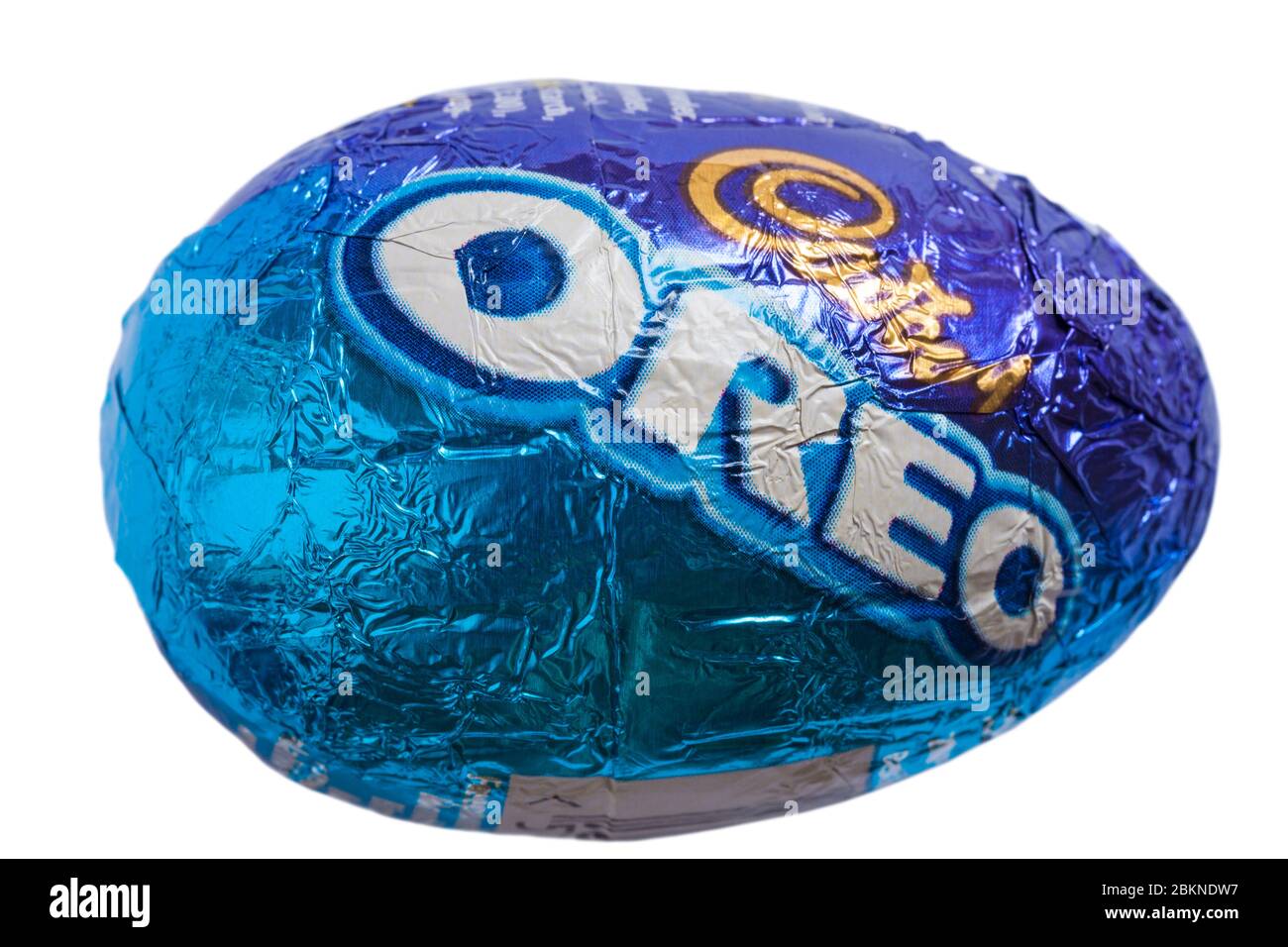 Oreo Easter Egg avec emballage en papier d'aluminium isolé sur fond blanc - œuf au chocolat au lait avec une crème de remplissage et des morceaux de biscuits Banque D'Images