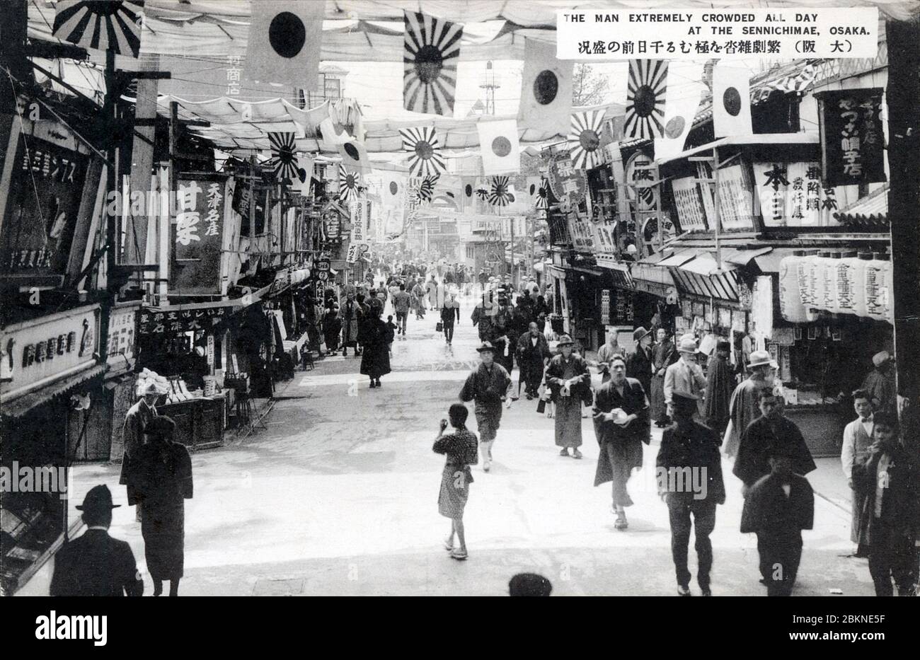 [ 1920 Japon - Osaka Entertainment District ] — les gens marchent sous les drapeaux à Sennichimae, Osaka. Depuis la période Edo (1603-1868), Sennichimae était avec le principal quartier de divertissement de Dotonbori Osaka. carte postale vintage du xxe siècle. Banque D'Images