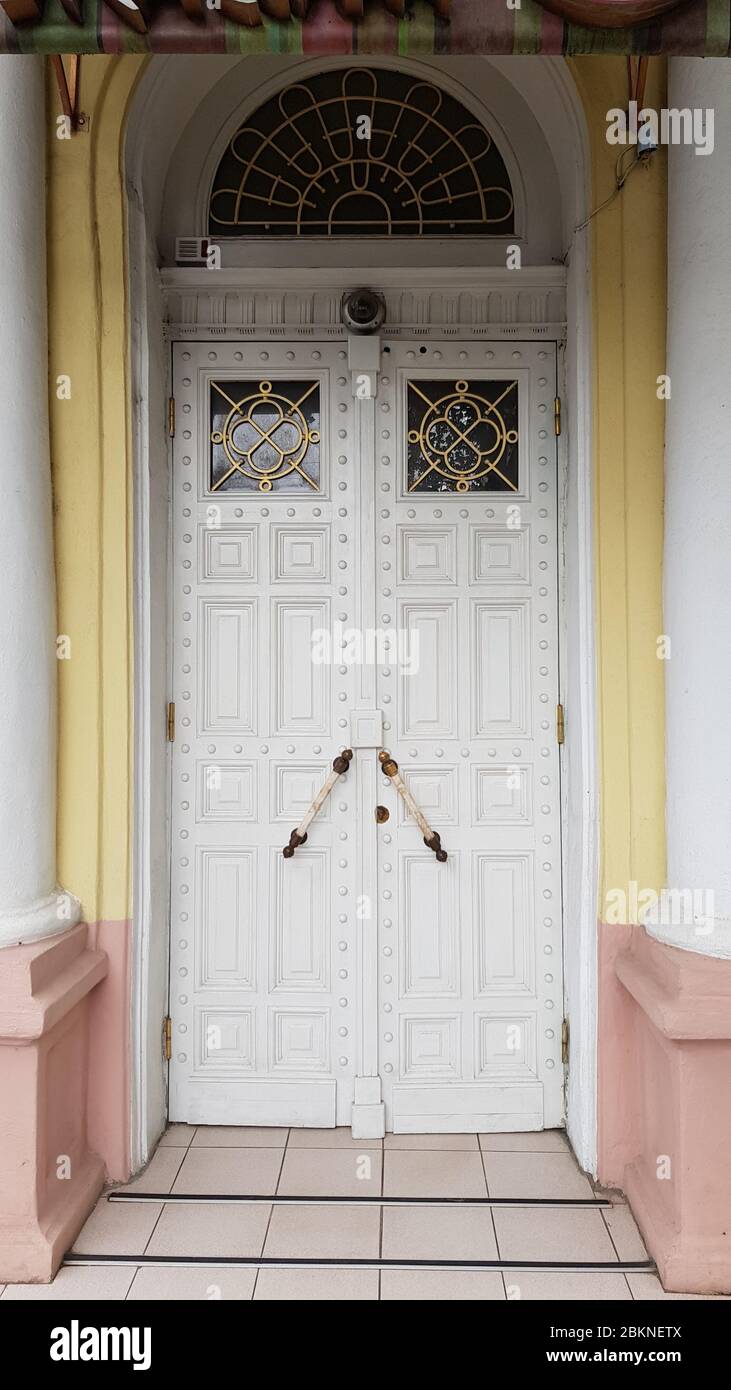 Élégante porte blanche ornée d'un bâtiment historique dans la ville européenne d'Odessa, en Ukraine. Colonnes classiques blanches à côté de l'entrée de la maison en pierre antique Banque D'Images