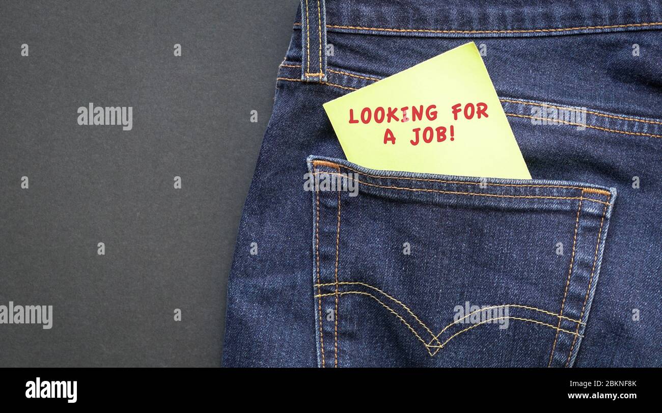 À la recherche d'un emploi, des mots en rouge sur un papier jaune sont collés de la poche du Jean. Concept d'emploi ou d'emploi. Banque D'Images