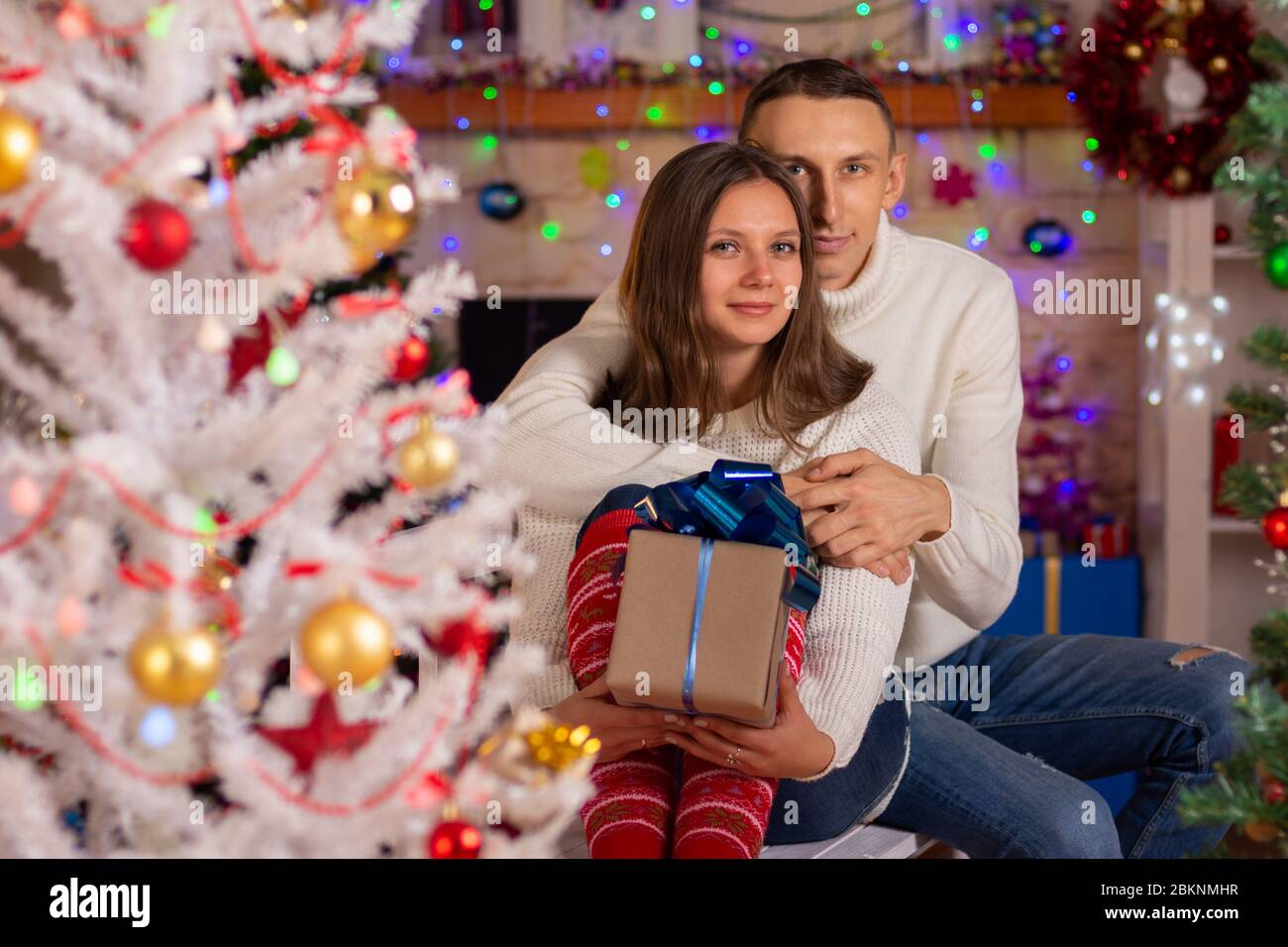 Un couple amoureux de cadeaux près d'un arbre de Noël Banque D'Images