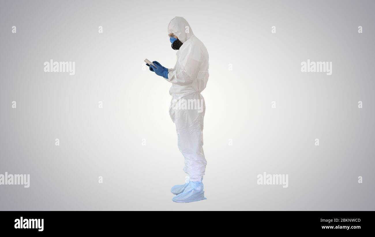 Médecin en costume de protection avec tablette numérique, concept Covid-19 sur fond dégradé. Banque D'Images