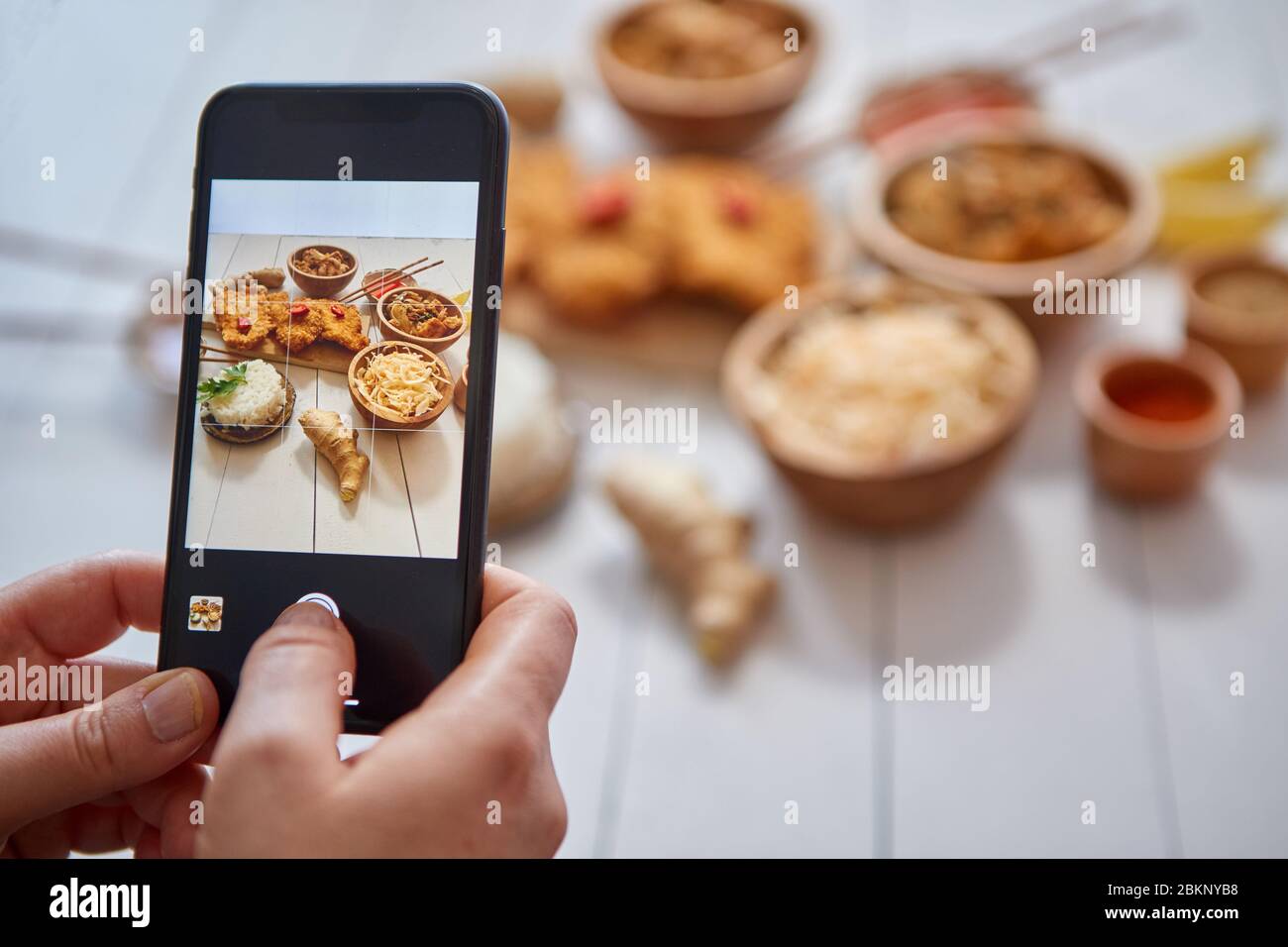 Femme prenant une photo avec un smartphone de poulet croustillant frite dans de la chapelure Banque D'Images