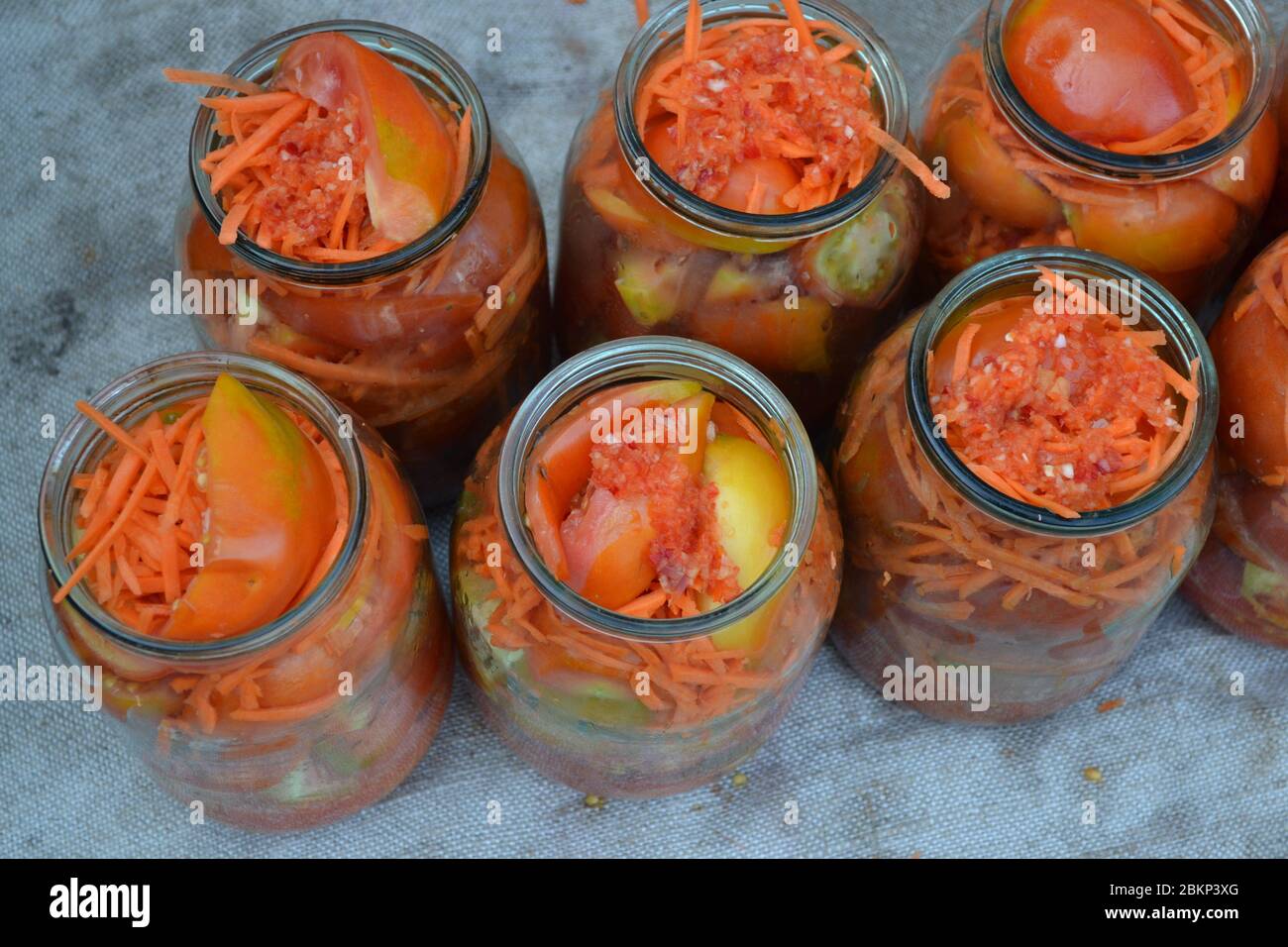 Conservation. Plats faits maison. Naturel. Carottes râpées, tomates rouges et jaunes en pots Banque D'Images