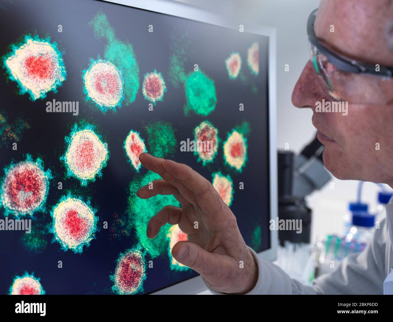 Recherche pharmaceutique sur les maladies et les pandémies. Un scientifique regarde une image du virus à l'aide d'un microscope électronique en laboratoire. Banque D'Images
