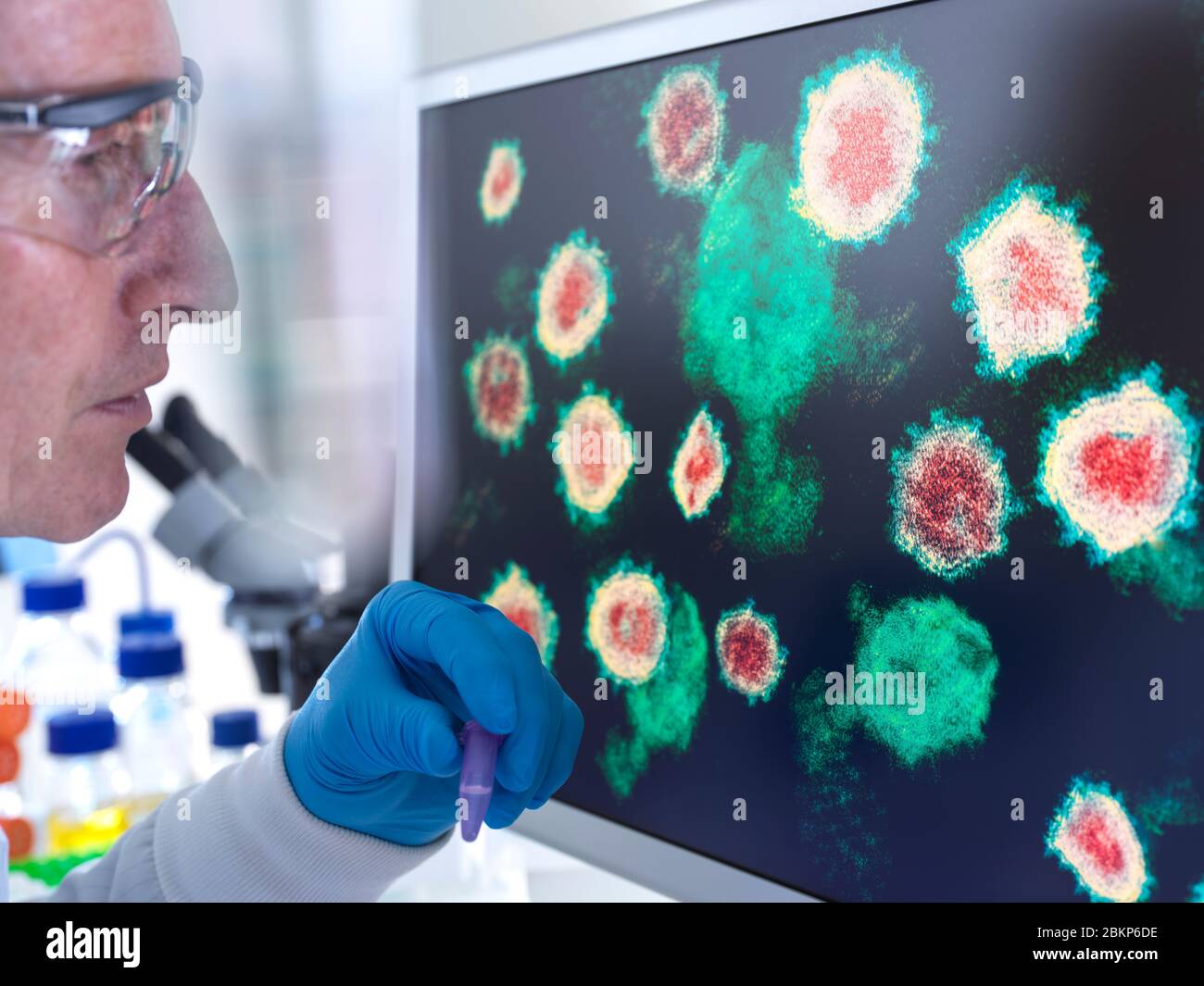 Recherche pharmaceutique sur les maladies et les pandémies. Un scientifique regarde une image du virus à l'aide d'un microscope électronique en laboratoire. Banque D'Images