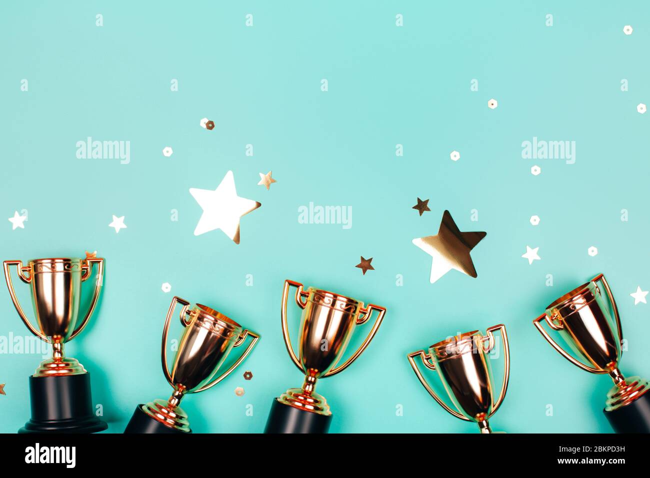 Golden CUPS de gagnant avec des confettis brillants sur un fond bleu avec espace de copie. Style plat. Banque D'Images