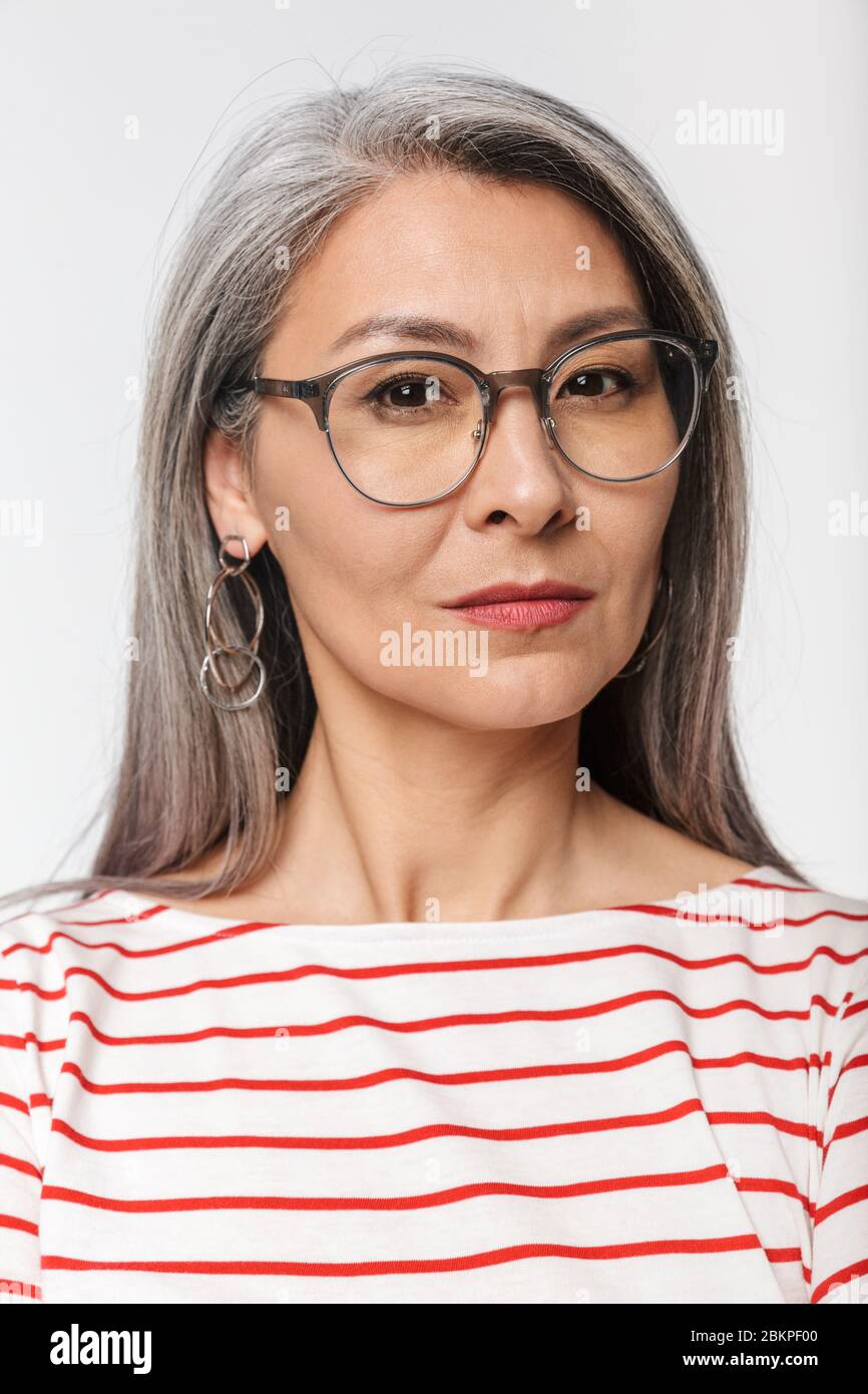 Image d'une femme adulte mature avec de longs cheveux gris portant des  lunettes de vue regardant l'appareil photo isolé sur fond blanc Photo Stock  - Alamy