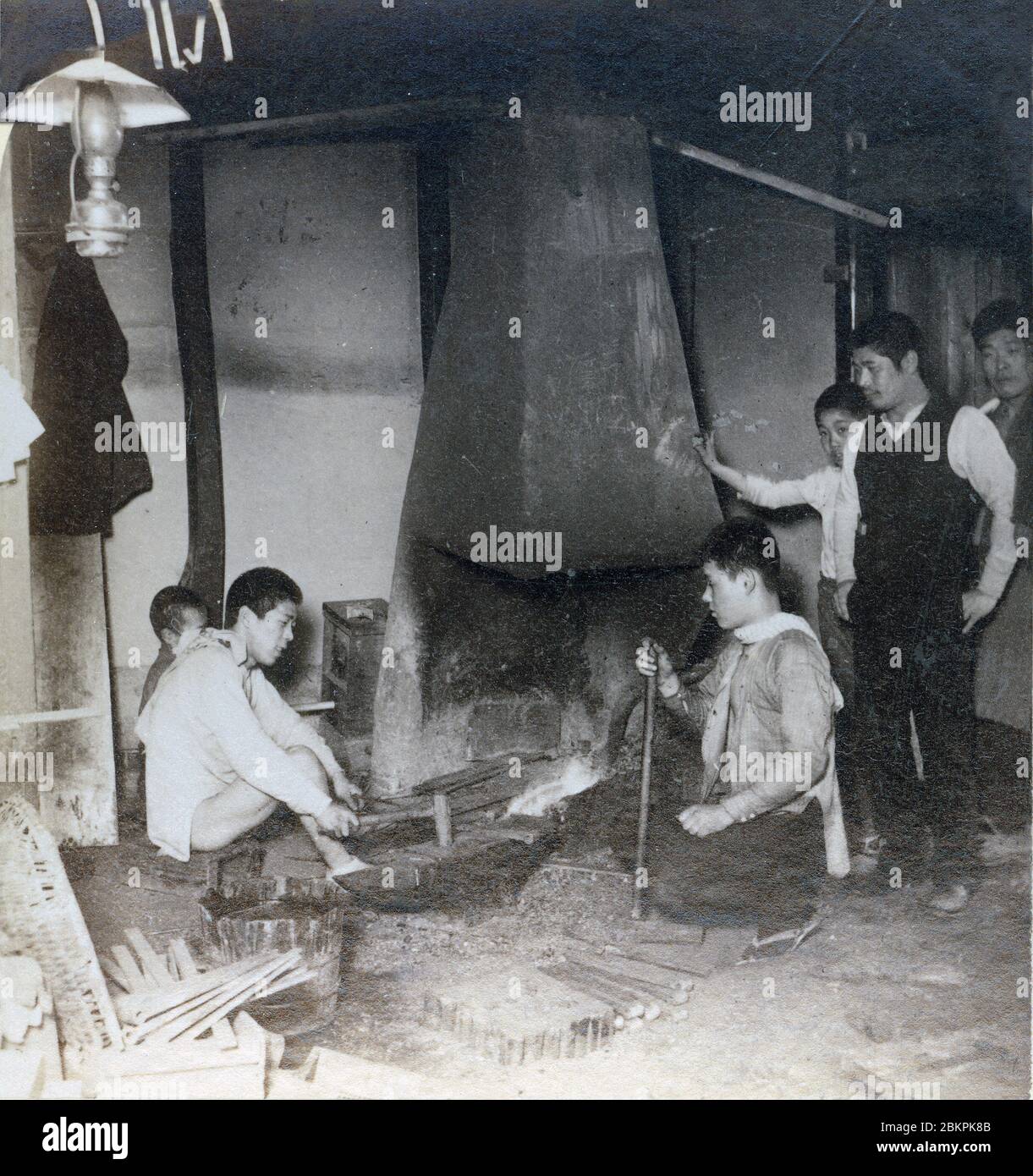 [ 1890s Japon - TITRE ] — jeune forgeron japonais assis au travail. chaîne stéréo du xxe siècle. Banque D'Images