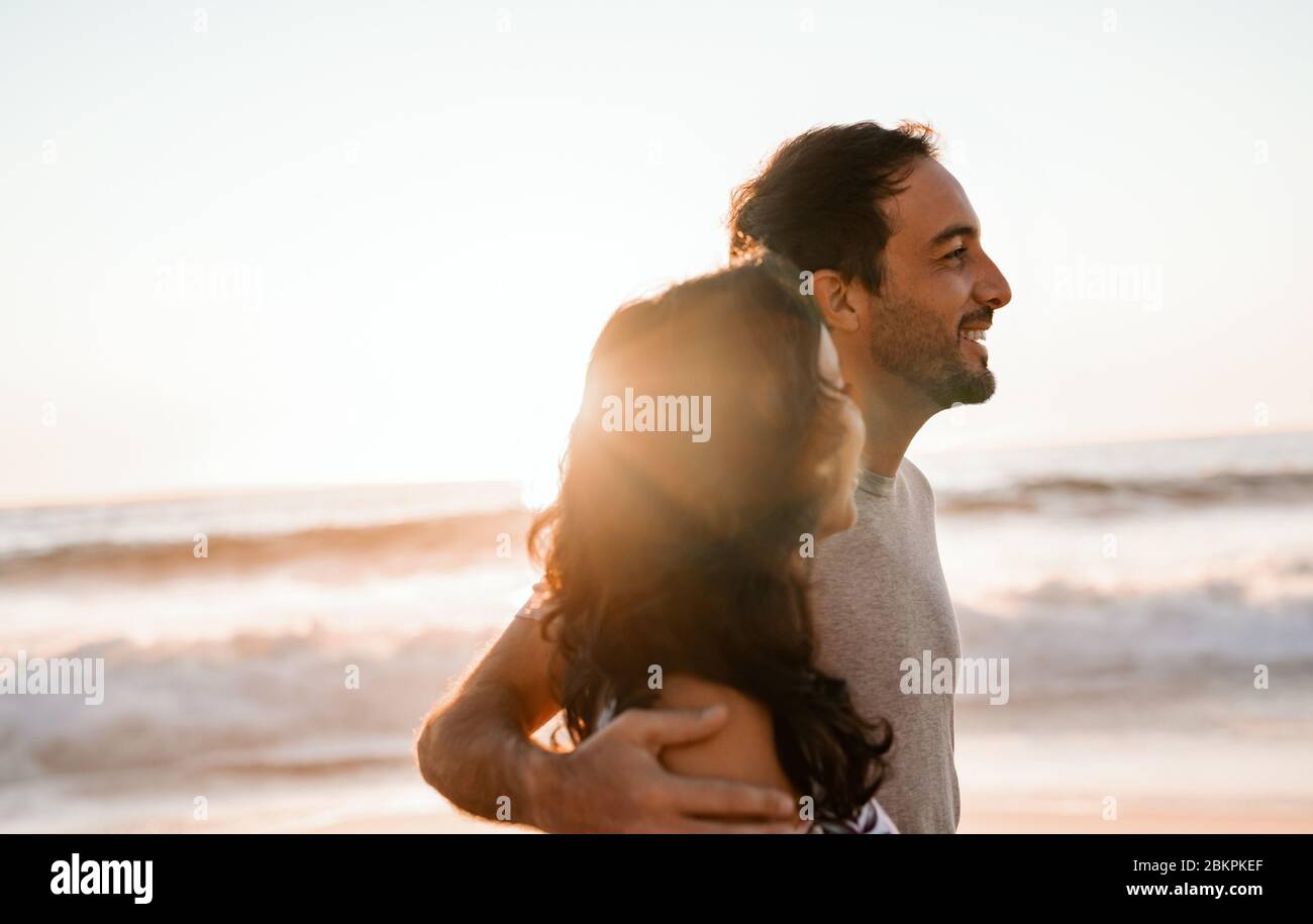 Un jeune couple se promenant ensemble au coucher du soleil au bord de l'océan Banque D'Images