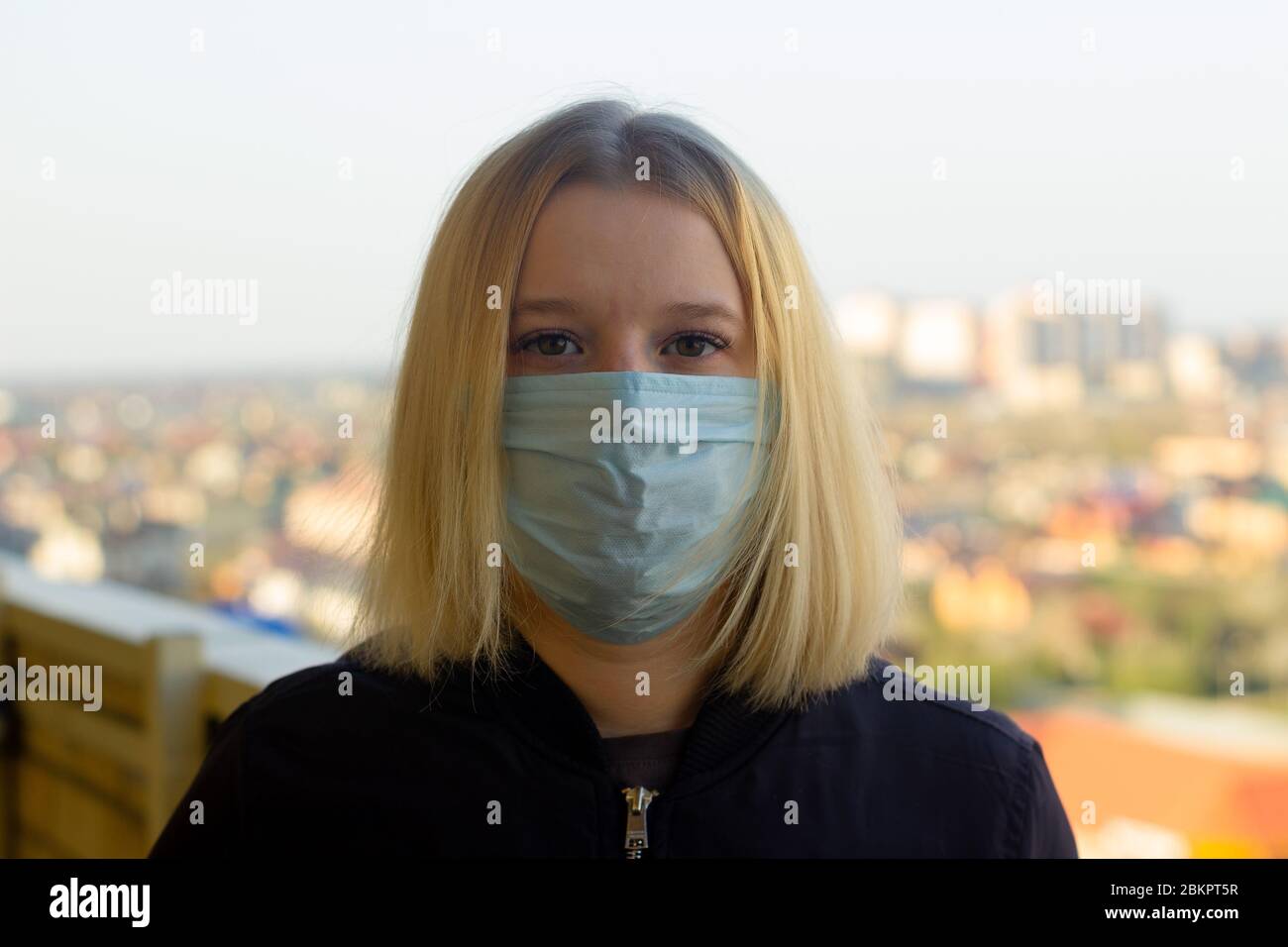Portrait de jeune femme avec masque médical, fond de ville flou. Concept covid-19 prévention pandémie mondiale de coronavirus Banque D'Images