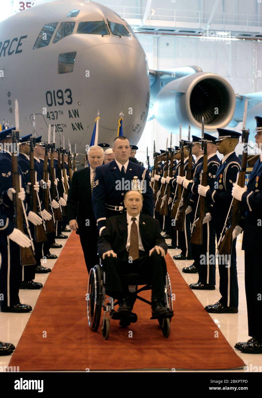 Dans cette photo publiée par l'US Air Force, le sénateur américain Strom Thurmond (républicain de Caroline du Sud), assis sur une chaise roulante, est aidé par l'intermédiaire d'un corson d'honneur de l'US Air Force pour couper un gâteau commémorant son 100e anniversaire lors d'une cérémonie à la base aérienne d'Andrews, Maryland, 12 décembre 2002. Au cours de la cérémonie, le 100e C-17 Globemaster III à sortir de la chaîne de montage a été baptisé « l'Esprit de Strom Thurmond ». Thurmond, ancien combattant de la Seconde Guerre mondiale, est sénateur américain depuis 48 ans et est membre de l'engagement des services armés et des anciens combattants du Sénat américain Banque D'Images