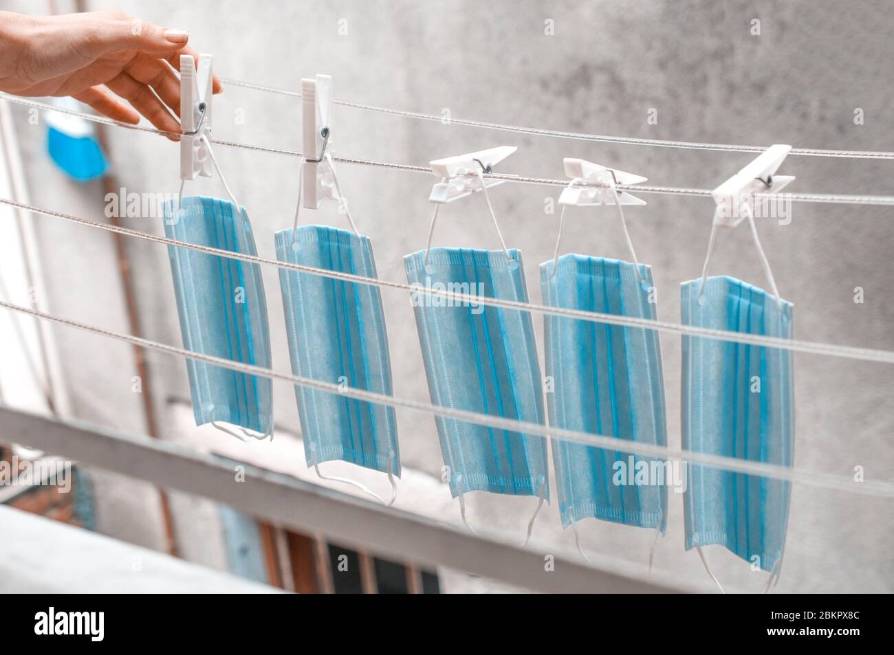 La femme porte des masques chirurgicaux à sécher au soleil Banque D'Images