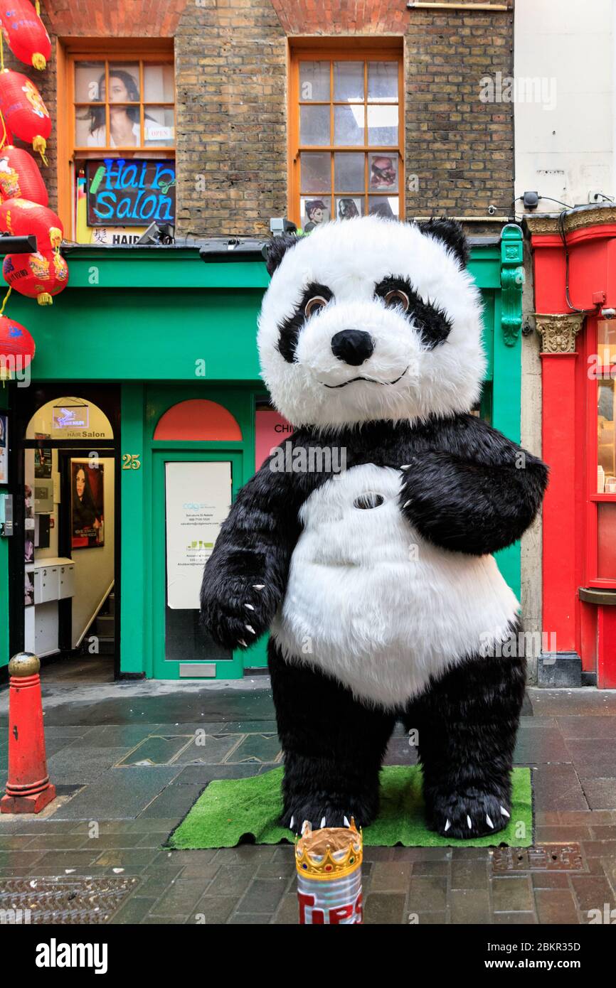 Un personnage de Panda géant devant les boutiques et les restaurants de Wardour Street dans Chinatown, Soho, Londres, décoré pour le nouvel an chinois Banque D'Images