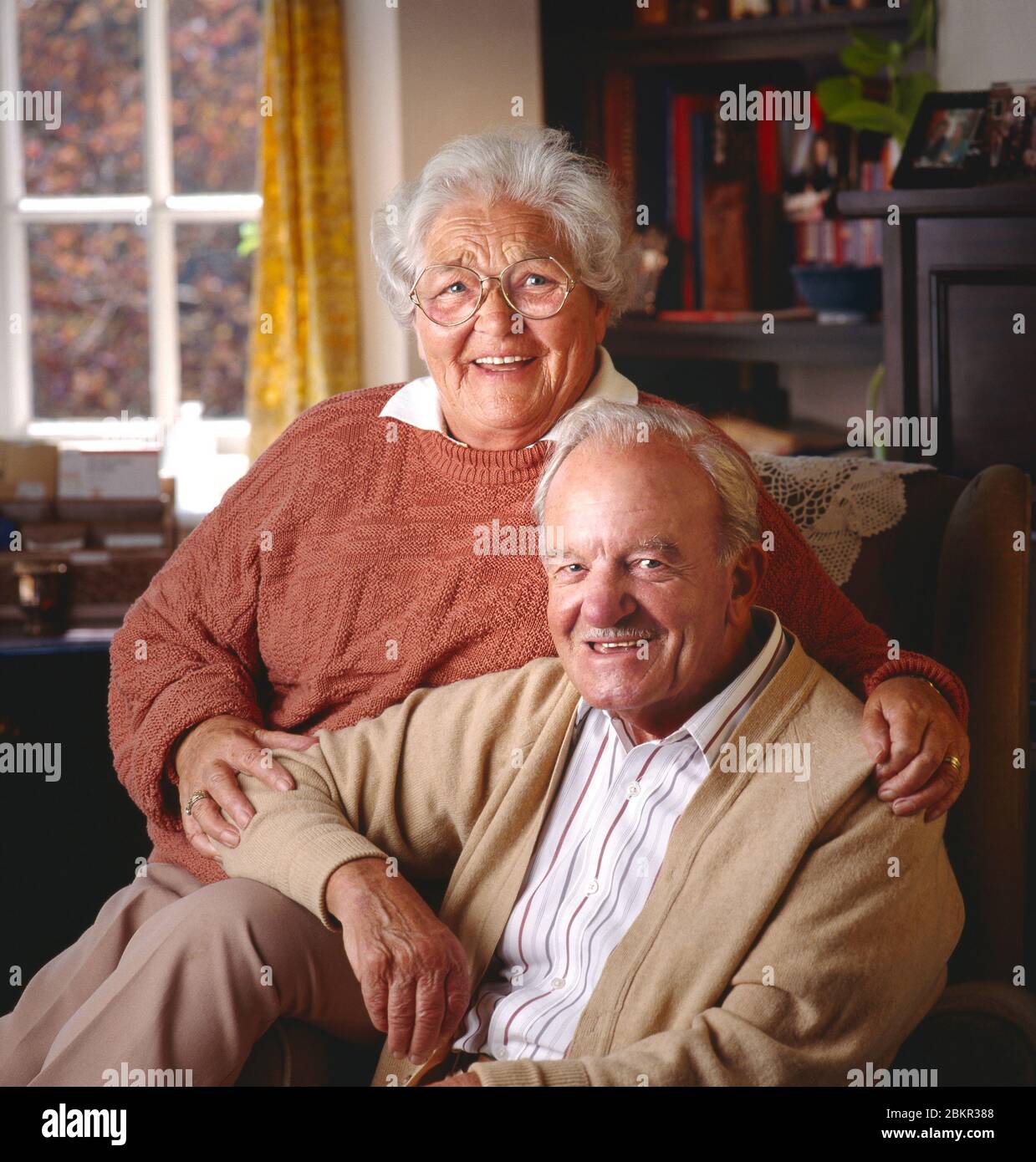 Couple de personnes âgées pensionné âgé âgé âgé âgé heureux couple en bonne santé 80-86 les propriétaires de maisons d'années assis à l'intérieur dans leur salon confortable face à l'appareil photo Banque D'Images
