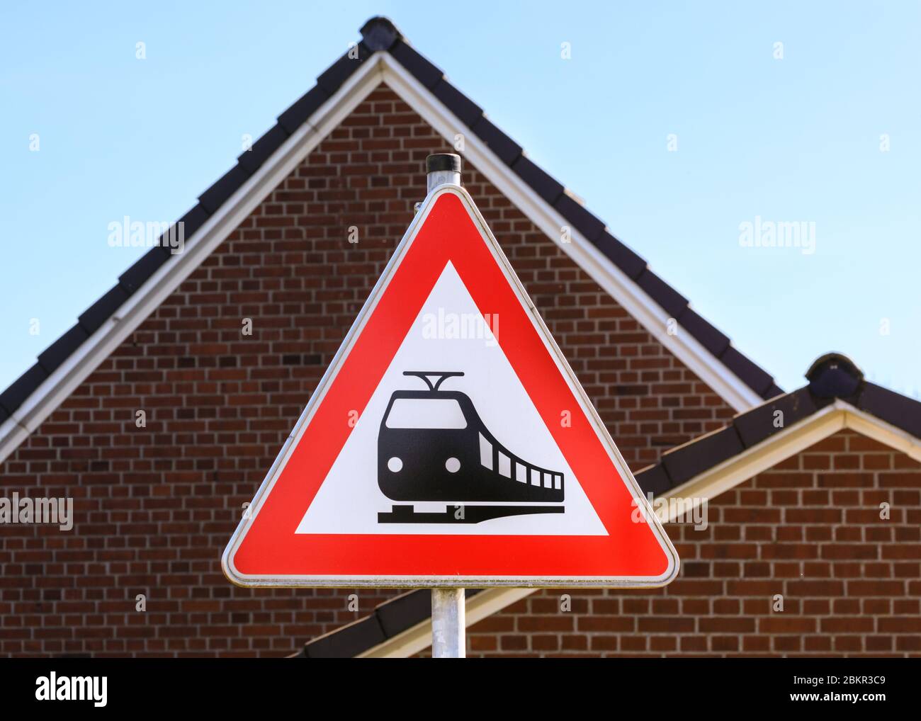 Passage à niveau de chemin de fer devant panneau d'avertissement, panneau triangulaire avec toit triangulaire en arrière-plan, Allemagne Banque D'Images