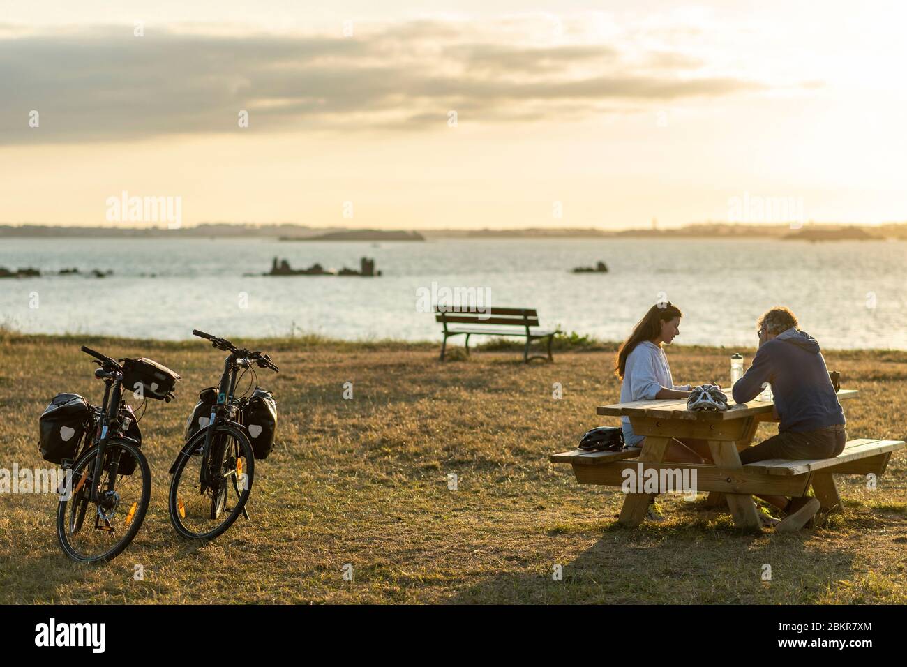 France, Finistère, Plougasnou, touristes cyclistes devant la plage de Saint-Samson au coucher du soleil, le long de la route maritime des vélos Banque D'Images