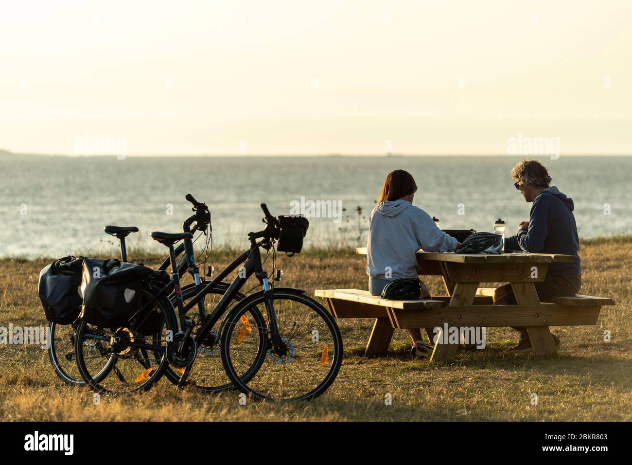 France, Finistère, Plougasnou, touristes cyclistes devant la plage de Saint-Samson au coucher du soleil, le long de la route maritime des vélos Banque D'Images