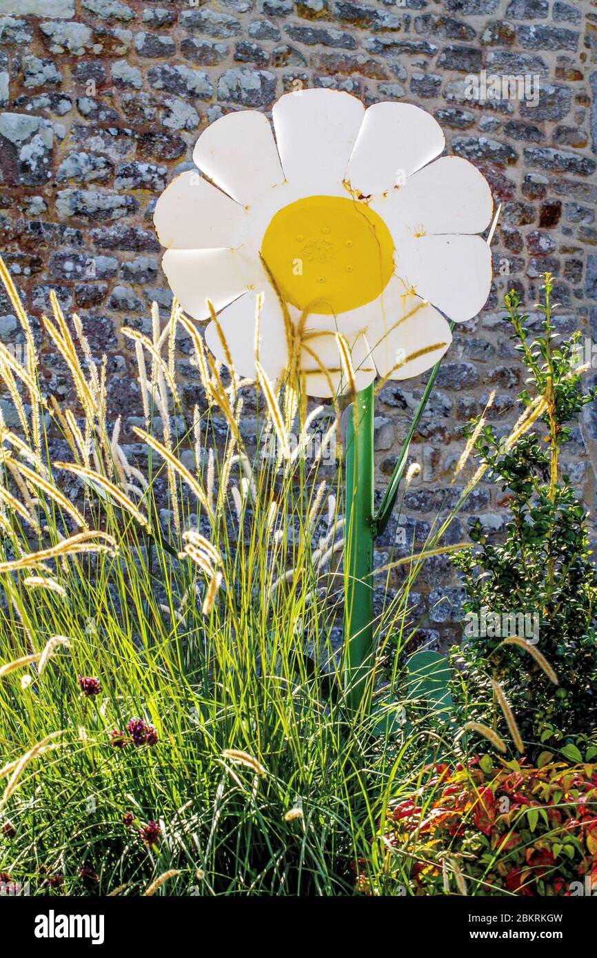 France, Morbihan, la VRAie Croix, Sculpture d'une Marguerite géante devant un mur de pierre Banque D'Images